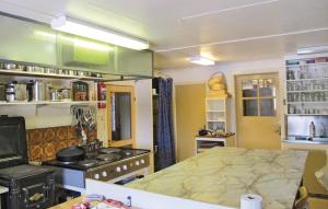 eine Küche mit einem Herd und einem Bett darin in der Unterkunft Awesome Home In Gräsmark With Sauna in Gräsmark + 19 Fotos