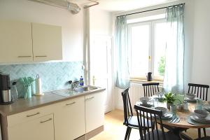 a kitchen and dining room with a table and a window at White Midsommar - Stilvolle Wohnung, 4 Schlafzimmer, Küche in Landshut