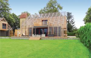 a wooden house with a lawn in front of it at Cozy Home In Kuhlen Wendorf With Wifi in Wendorf