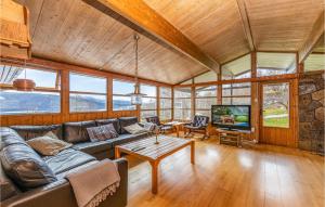 a living room with a couch and a table and a tv at Awesome Home In Vatne With House A Panoramic View in Vatne