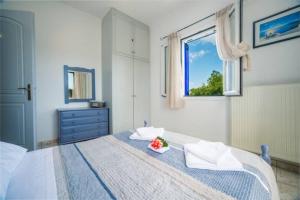 a bedroom with a bed with a bowl of flowers on it at Tsilivi Blue Vista Apartment in Tsilivi