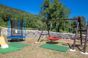 a group of swings in a park at Villa Simici quiet peaceful place with pool perfect to enjoy the nature in Mošćenička Draga