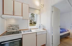 a kitchen with white cabinets and a sink and a window at Frische Brise 16 - Dorf 3 in Priwall