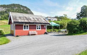 una piccola casa rossa con due panchine e una tenda di Eikhaugen Gjestegard a Vinnes