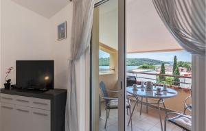a room with a balcony with a table and a television at Nice Apartment In Pula With Kitchen in Pula