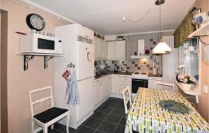 a small kitchen with a table and a clock on the wall at Awesome Home In Fagersanna With 1 Bedrooms in Fagersanna