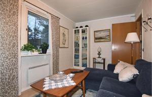 a living room with a blue couch and a table at One-Bedroom Holiday Home In Fagersanna in Fagersanna