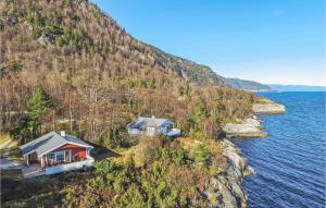 a house on a cliff next to the water at Nice Home In Lavik With 3 Bedrooms And Wifi in Lavik