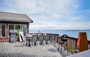 um deque com cadeiras e uma mesa com vista para a água em Lovely Home In Nedstrand With Sauna em Nedstrand
