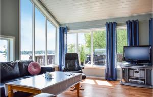 uma sala de estar com um sofá e uma televisão em Lovely Home In Nedstrand With Sauna em Nedstrand