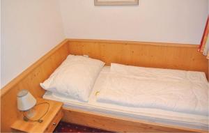 a bed with a wooden frame with a pillow and a table at Amazing Apartment In Flachau With 2 Bedrooms And Internet in Flachau