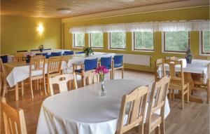 una sala da pranzo con tavoli bianchi e sedie blu di 4 Bedroom Gorgeous Apartment In Finspng a Kolvetorp