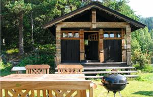a small cabin with a grill and a table and bench at 6 Bedroom Amazing Home In Hydalsmo in Ofte