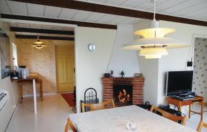 een woonkamer met een tafel en een open haard bij Pet Friendly Home In Hjrnarp With Wifi in Hjärnarp