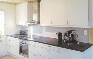 a kitchen with white cabinets and a sink at 4 Bedroom Amazing Home In Sira in Sira