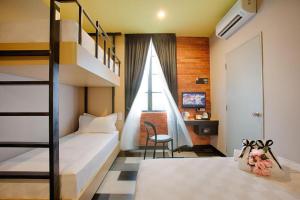 a bedroom with two bunk beds and a staircase at the youniQ Hotel, Kuala Lumpur International Airport in Sepang