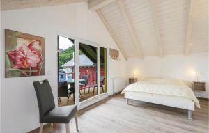 ein Schlafzimmer mit einem Bett, einem Stuhl und einem Fenster in der Unterkunft Ferienhausdorf Thale in Thale