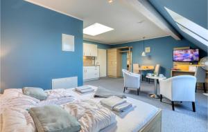 ダゲビュルにあるGorgeous Apartment In Dagebll With Kitchenの青い壁のベッドルーム1室(大型ベッド1台付)