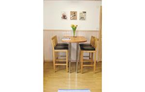 une table avec des chaises et un vase de fleurs. dans l'établissement 3 Bedroom Stunning Home In nimskog, à Säljebyn