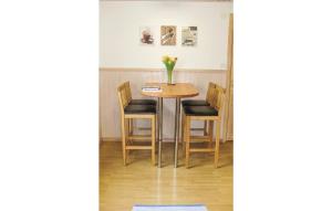 a table with chairs and a vase of flowers on it at Holiday Home Kilane Ånimskog in Säljebyn +7 photos