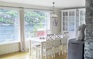 a dining room with a table and a view of the water at Nice Home In Dalsyra With 4 Bedrooms And Wifi in Oppdalsøyra