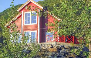 uma casa vermelha no topo de uma parede de pedra em Nice Home In Vaksdal With House A Mountain View em Stavenesli