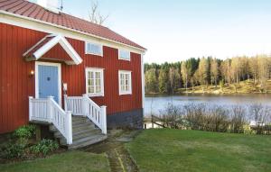 uma casa vermelha com uma escada branca ao lado de um lago em 4 Bedroom Nice Home In Bottnaryd em Bottnaryd