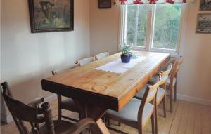 a wooden table in a room with chairs around it at Lovely Home In Ljung With Lake View in Ljung