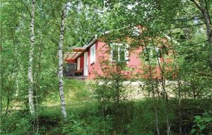 a pink house in the middle of the forest at Lovely Home In Ljung With Lake View in Ljung