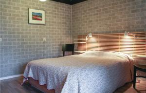 een slaapkamer met een bed en een bakstenen muur bij Stunning Home In Reutum With 3 Bedrooms And Wifi in Reutum