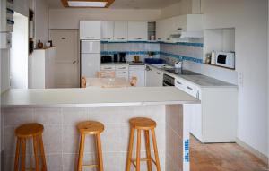 una cocina con barra y dos taburetes. en Gorgeous Home In Channay-sur-lathan With Kitchen, en Channay-sur-Lathan