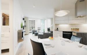 uma cozinha e sala de estar com uma mesa branca e cadeiras em Lovely Apartment In Lbeck Travemnde With Sauna em Travemünde