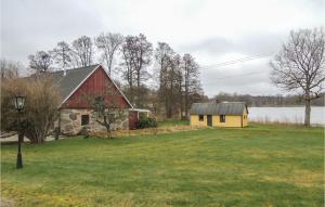 a red and yellow house next to a lake at 2 Bedroom Nice Home In Urshult in Urshult
