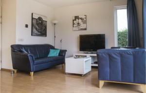 ein Wohnzimmer mit 2 Stühlen und einem TV in der Unterkunft Porta Isola - Villa Land 127 in Stevensweert