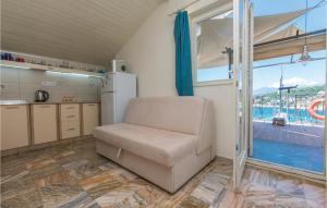 Zimmer mit einem Stuhl und einer Küche mit einem Pool in der Unterkunft Awesome Apartment In Utjeha With Kitchen in Utjeha
