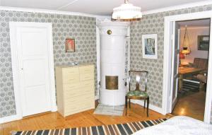 a living room with a fireplace and a chair at Gormetorp in Barnebo