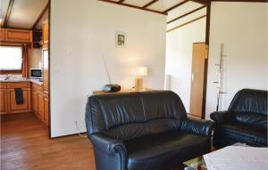 a living room with a leather chair and a lamp at 2 Bedroom Cozy Home In Gerolstein in Gerolstein +18 photos