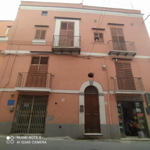 różowy budynek z balkonami i drzwiami w obiekcie DIMORA LETIZIA -APARTMENT w mieście Procida
