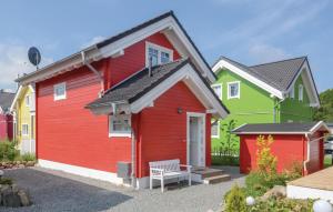 ein rotes und grünes Haus mit einer Bank davor in der Unterkunft Seehund 5 in Süssau
