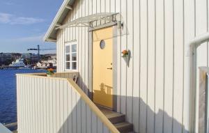 a building with a yellow door and stairs next to the water at Beautiful Apartment In Skärhamn in Skärhamn +13 photos