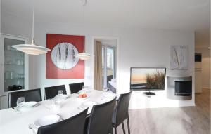 uma sala de jantar branca com uma mesa e cadeiras brancas em Dnenvilla em Travemünde