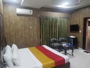 1 dormitorio con 1 cama con una manta colorida en Quick continental Hotel - Jail Road, en Lahore