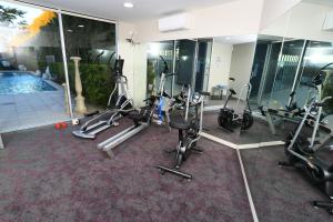 a gym with exercise bikes and a swimming pool at Springfield Lakes Boutique Hotel in Springfield Lakes