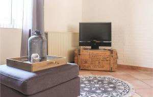 a living room with a chair and a tv on a box at Vakantiewoning 11 in Simpelveld +4 photos