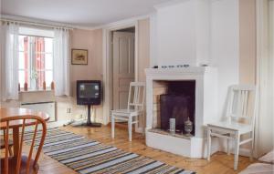 a living room with a fireplace and a tv at Two-Bedroom Holiday Home In Vimmerby in Vimmerby +10 photos