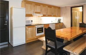 a kitchen with a wooden table and a white refrigerator at Cozy Apartment In Hemsedal With House A Mountain View in Hemsedal