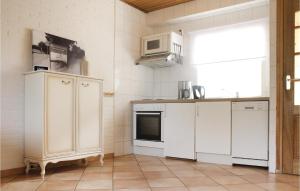 a kitchen with white appliances and a window at Vakantiewoning 11 in Simpelveld