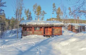 a wooden cabin in the snow with snow on the ground at Holiday Home Vråliosen Bandaksliv, in Bandaksli +9 photos