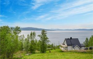ein Haus auf einem Hügel mit Blick auf das Wasser in der Unterkunft Cozy Home In Ballangen With Wifi in Ballangen