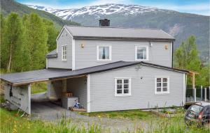 ein weißes Haus mit einer Garage vor einem Berg in der Unterkunft Cozy Home In Ballangen With Wifi in Ballangen